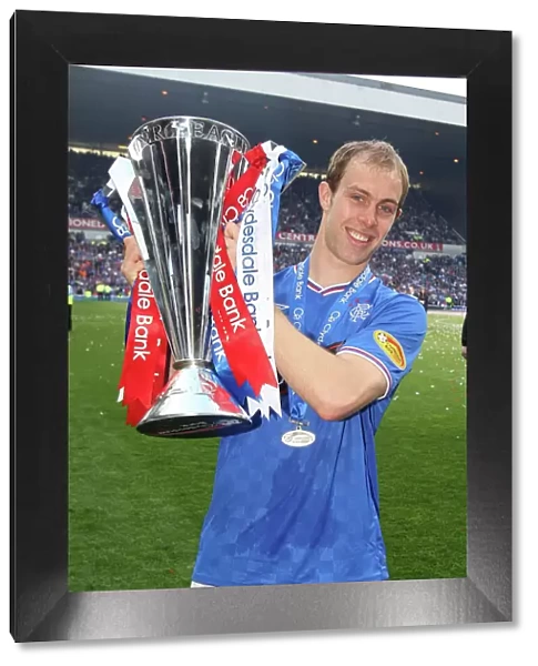 Rangers Football Club: Steven Whittaker's Triumphant Moment with the SPL Trophy at Ibrox Stadium