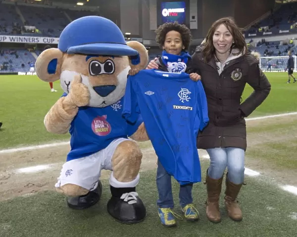 A Bittersweet Reunion: Rangers Fan and Broxi Bear with Signed Shirt Amidst the Disappointment of a 1-2 Loss at Ibrox Stadium