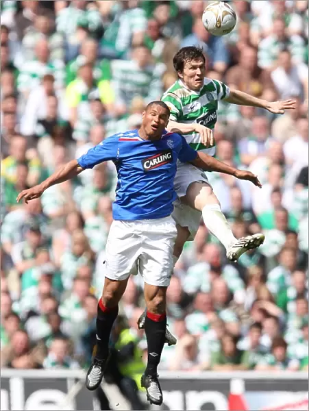 Intense Rivalry: Clydesdale Bank Premier League - Celtic vs Rangers: Aerial Battle Between Daniel Cousin and Gary Caldwell (3-2 in Favor of Celtic)