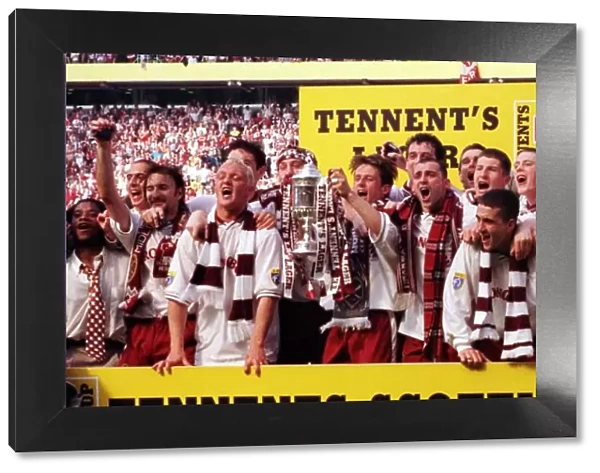 Heart of Midlothian footballers celebrate with the Scottish Cup trophy after defeating
