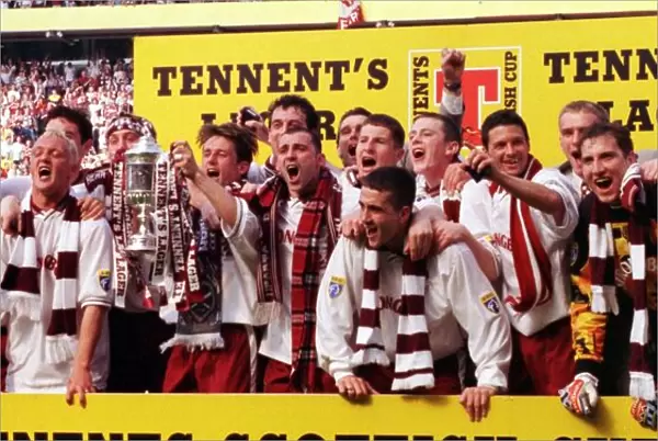 Heart of Midlothian footballers celebrate with the Scottish Cup trophy after defeating