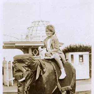 Little girl and her toy dog ride a model Elephant - Margate