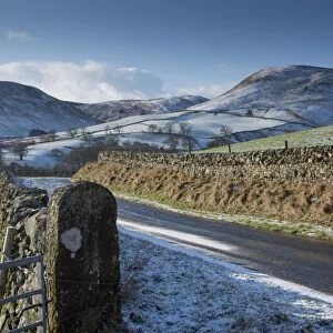 View of road, drystone walls and snow covered hills, near Thornhill, Dumfries and Galloway, Scotland, January