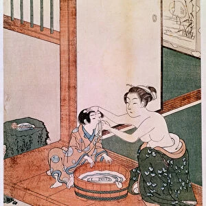 A naked mother washing her child in Japan near a basin filled with water