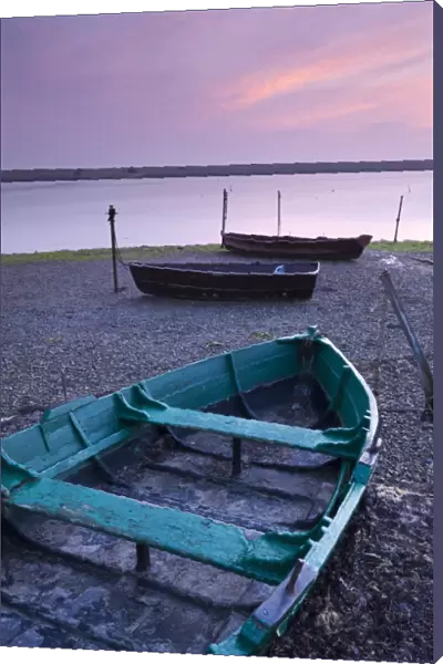 Boats at low tide on the shore of The Fleet lagoon, Chesil Beach, Dorset, England. Spring
