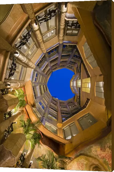 Bottom view of the inner courtyard of Casa Mila or La Pedrera at dusk, Barcelona
