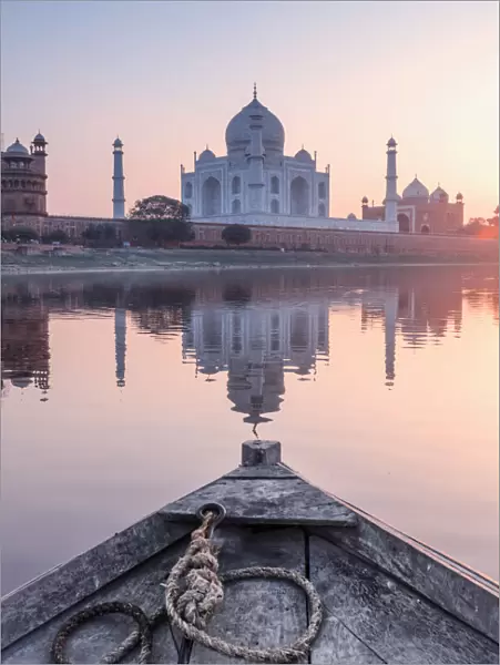 India, view of the Taj Mahal reflecting in the Yamuna river at sunset from a wooden boat