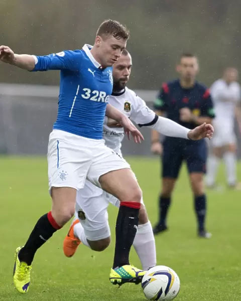 Rangers Lewis Macleod Stands Firm Against Dumbarton's Chris Turner in Intense SPFL Championship Battle