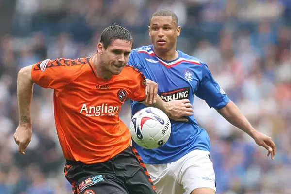 Intense Rivalry: Lee Wilkie vs. Daniel Cousins - Thrilling Battle for the Ball at Ibrox (Rangers 3-1 Dundee United)