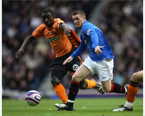 Rangers vs Dundee United: A Tight Battle for the Ball - John Fleck vs Prince Buaben at Ibrox Stadium (2-0 in Favor of Rangers)