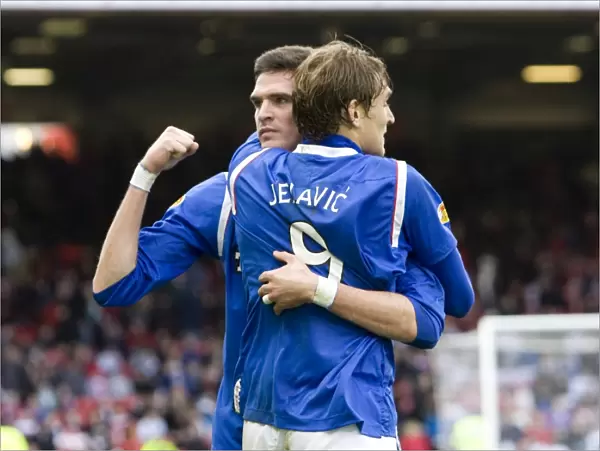 Rangers Lafferty and Jelavic: Celebrating a Hard-Fought 2-1 Victory at Pittodrie Stadium