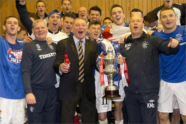 Rangers players and management celebrate with the Irn Bru Third Division trophy in the dressing room