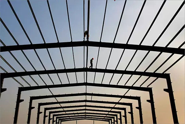 A labourer walks on a steel frame at a construction site in Nanjing