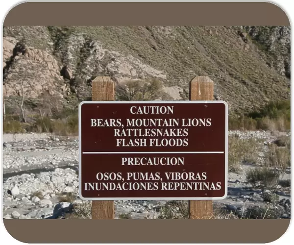 Caution, Bears, Mountain Lions, Rattlesnakes, Flash Floods bilingual warning sign in desert, Whitewater Preserve, Southern California, U. S. A