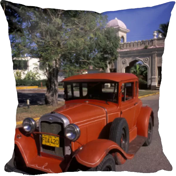 Cuba, Cien Fuergos, Old Model A Ford and colorful architecture behind