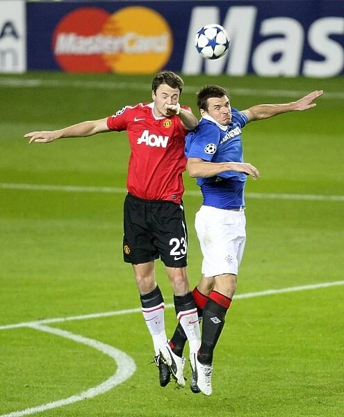 Aerial Clash: Lee McCulloch vs. Jonathan Evans in Rangers vs Manchester United (UEFA Champions League Group C: 0-1 to Manchester United)