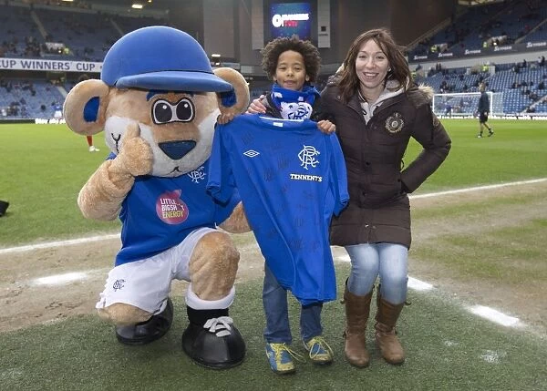 A Bittersweet Reunion: Rangers Fan and Broxi Bear with Signed Shirt Amidst the Disappointment of a 1-2 Loss at Ibrox Stadium