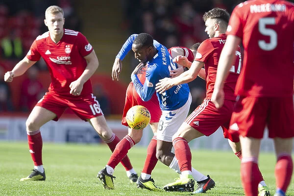 Rangers vs Aberdeen: Glen Kamara's Intense Battle for the Ball in the Scottish Cup Quarter-Final at Pittodrie Stadium