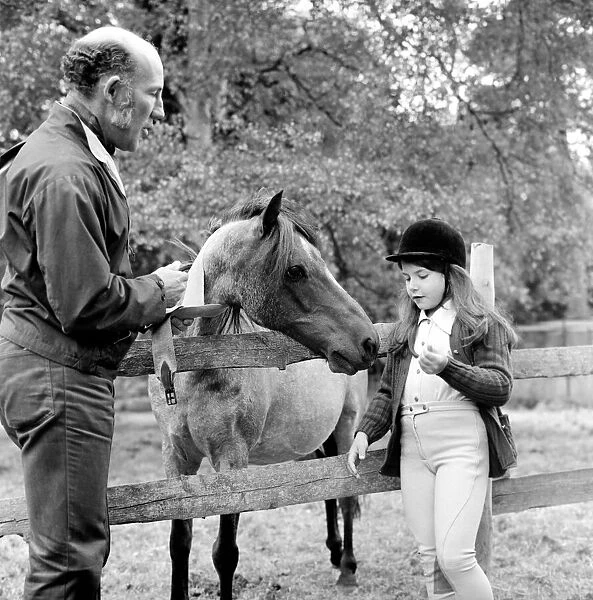 Sterling Moss (Ex Racing Driver). Seen here with horse and daughter
