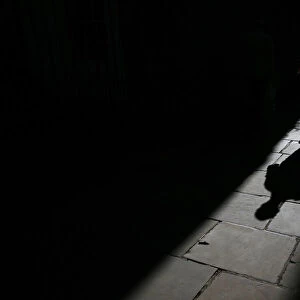 A man casts a shadow as he walks along an alleyway in central London