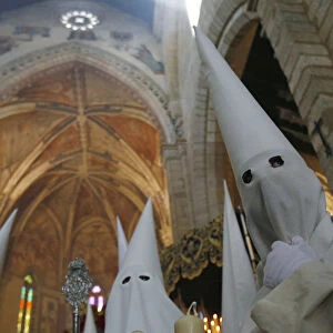 Penitents take part in the procession of La Borriquita brotherhood during Holy Week in