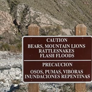 Caution, Bears, Mountain Lions, Rattlesnakes, Flash Floods bilingual warning sign in desert, Whitewater Preserve, Southern California, U. S. A