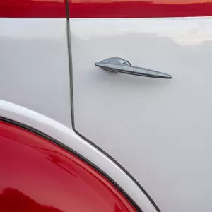 Detail of door on red and white classic American Ford in Habana, Havana, Cuba