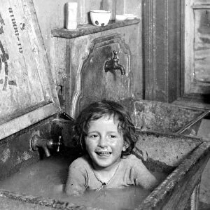 NYC: TENEMENT LIFE, c1900. Bathing in the kitchen sink on the Lower East Side