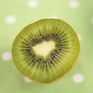Half cut kiwi fruit on green polka dot tablecloth