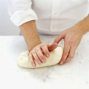 Using palm of right hand to press down dough