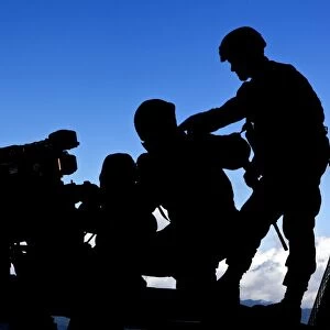 Silhouette of soldiers operating a BGM-71 TOW guided missile system
