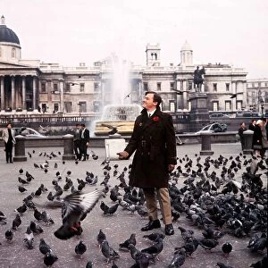 American actor Robert Vaughn feeds the pigeons in Trafalgar Square