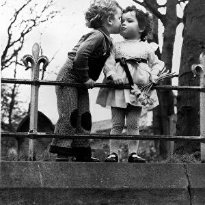 A child plants a peck on another on Love Lane. Circa 1970