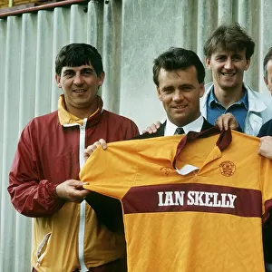 New Motherwell signing Davie Cooper poses with the team shirt as he stand with management